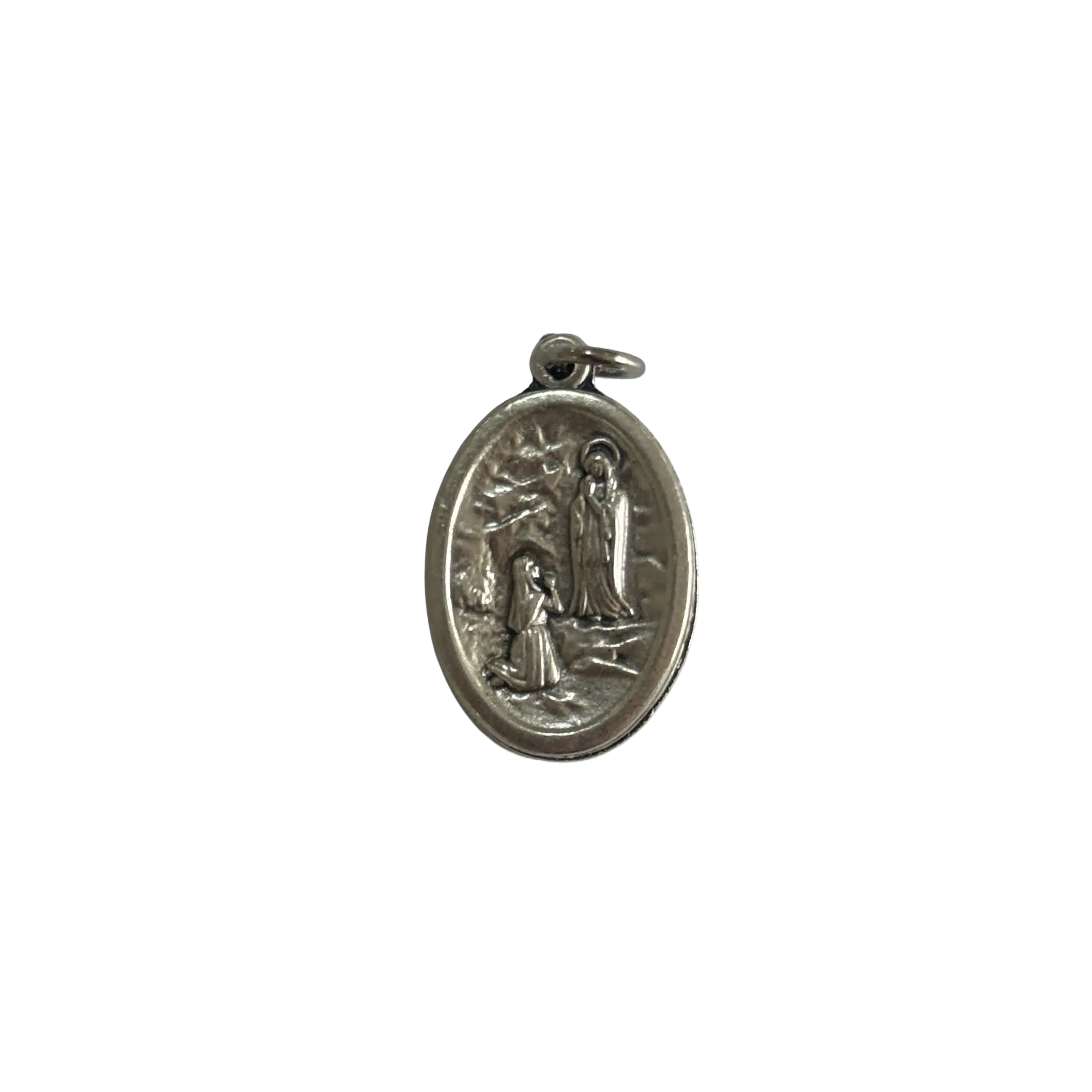 Reverse side of a silver St Bernadette medal depicting the apparition of Our Lady of Lourdes in the grotto.